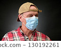Closeup portrait of a elderly man in studio wearing a facial mask 130192261