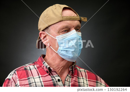 Closeup portrait of a elderly man in studio wearing a facial mask 130192264