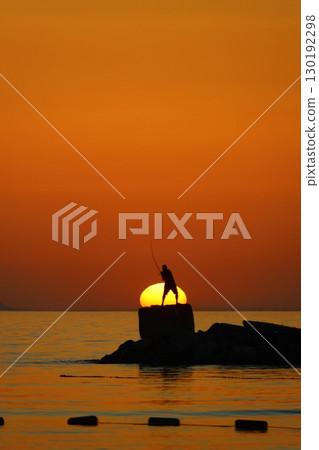 Tourists on holiday in the famous resort town of Bodrum spend time fishing at sunset. 130192298