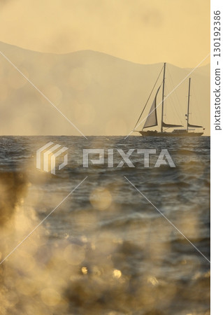 Alone sailboat at sunset. Atmospheric seascape with orange sun. Alone sailboat at sunset. Atmospheric seascape with orange sun. 130192386
