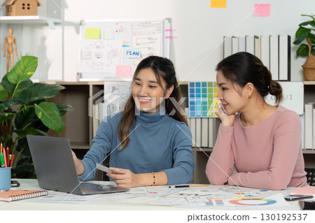 UX and UI designers discussing project ideas with laptop UX and UI designers discussing project ideas with laptop 130192537