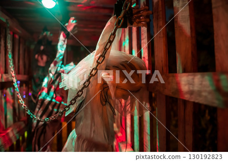 Spooky bride in bridal gown chain by handcuffs in cage. 2025 Halloween Spooky bride in bridal gown chain by handcuffs in cage. 2025 Halloween 130192823