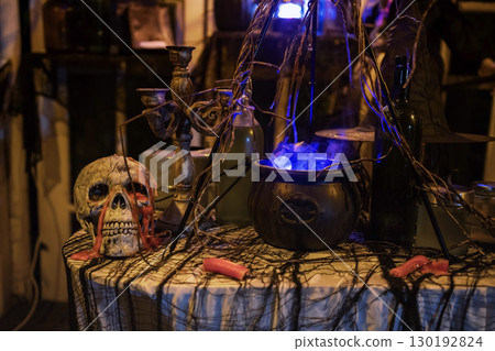 Skull and magic witch spell pot on dirty table. 2025 Haloween decor Skull and magic witch spell pot on dirty table. 2025 Haloween decor 130192824