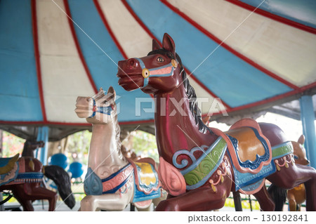 Old Merry-go-round horses in amusement park 130192841