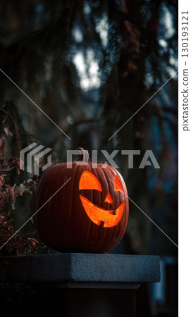 Jack o lantern glowing at dusk in autumn setting 130193121