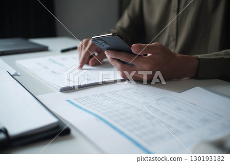 Businessman reading report in office desk analyze data for plan project 130193182