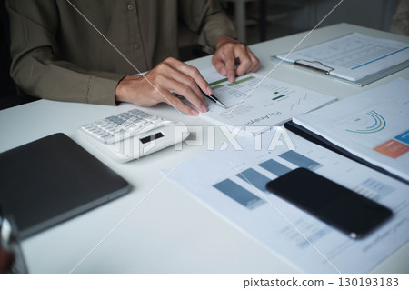Businessman reading report in office desk analyze data for plan project 130193183