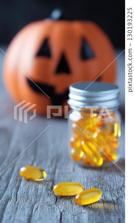 Colorful capsules and Halloween pumpkin decoration 130193225
