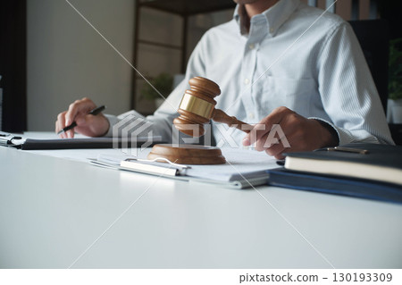 Legal justice man working on desk reading supportive documents to determine the consulting case 130193309