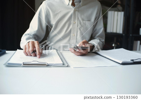 Legal justice man working on desk reading supportive documents to determine the consulting case 130193360