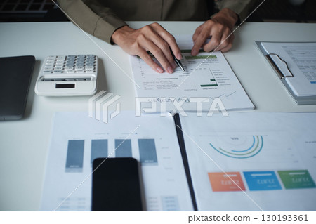 Businessman reading report in office desk analyze data for plan project 130193361