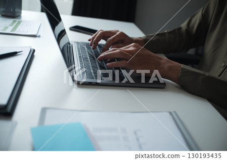 Businessman, entrepreneur, accountant working on financial report on desk using laptop. 130193435