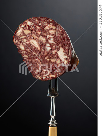 Black pudding or blood sausage on a fork. 130193574
