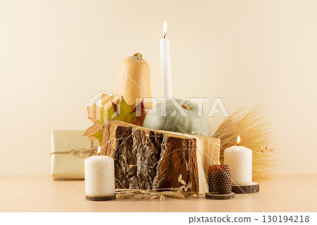 Thanksgiving holiday composition with pumpkins, dry autumn leaves, bouquet of rye and wheat ears, gifts and candles on a wooden podium on a beige background. Happy Thanksgiving Day Card Thanksgiving holiday composition with pumpkins, dry autumn leaves, bouquet of rye and wheat ears, gifts and candles on a wooden podium on a beige background. Happy Thanksgiving Day Card 130194218