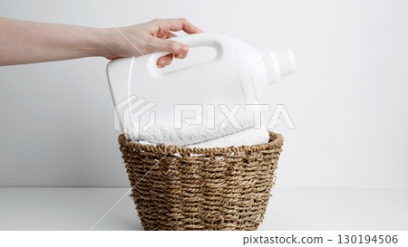 Laundry detergent branding mock up and basket filled with clean white towels. Household cleaning and hygiene concept packaging Laundry detergent branding mock up and basket filled with clean white towels. Household cleaning and hygiene concept packaging 130194506