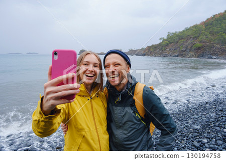 Couple taking selfie on beach in Winter Couple taking selfie on beach in Winter 130194758