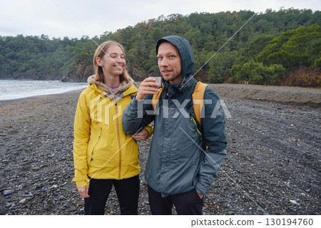 Couple drinks tea by winter sea shore 130194760