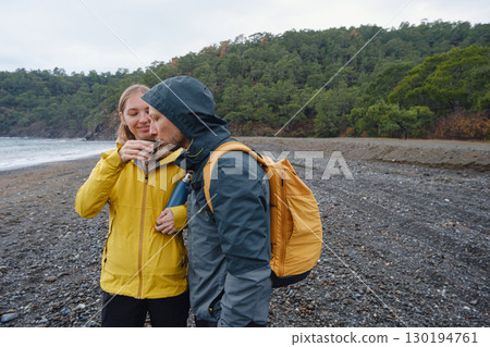 Couple drinks tea by winter sea shore 130194761