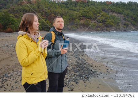 Couple drinks tea by winter sea shore 130194762