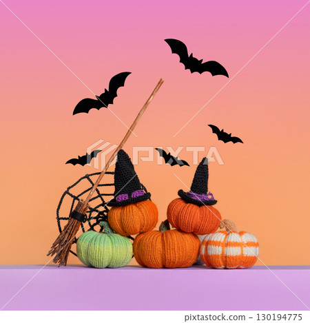 Knitted green orange pumpkins, knitted black spider web, bats and a witch's broom on gradient background, front view. Halloween concept. Handmade knitted toys for children and holiday home decor. Knitted green orange pumpkins, knitted black spider web, bats and a witch's broom on gradient background, front view. Halloween concept. Handmade knitted toys for children and holiday home decor. 130194775