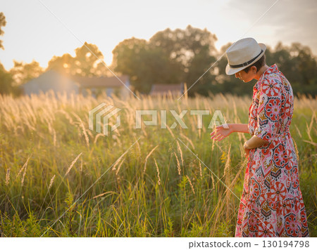 boho chic woman in a floral dress in European countryside boho chic woman in a floral dress in European countryside 130194798