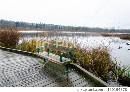 Wooden chair on a wooden dock at the Burnaby Lake Regional Park, BC, Canada 130194878