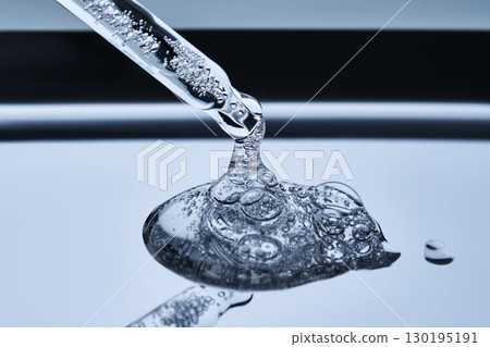 A pipette with hyaluronic serum on a blue background. 130195191