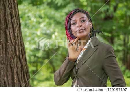 African businesswoman posing outdoors in natural forest setting professional portrait among trees 130195197