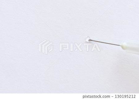 close up of needle piercing white paper surface with precision and delicate 130195212