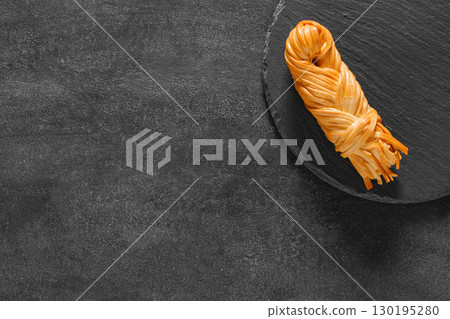 suluguni cheese in pigtail on slate panel, top view 130195280