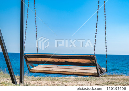 empty swing on chains against background of sea 130195606