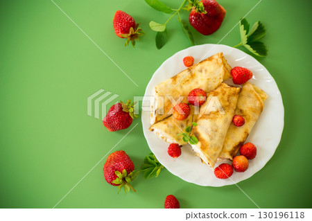 Delicious pancakes with strawberries and soft cottage cheese Delicious pancakes with strawberries and soft cottage cheese 130196118