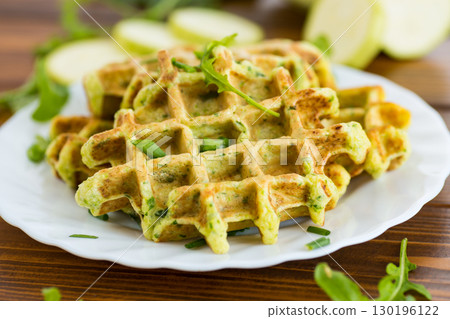 Waffles with green onions, zucchini and spices on a wooden table 130196122