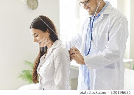 Doctor Or Nurse Using Stethoscope To Check Female Patient Lungs At Clinic Doctor Or Nurse Using Stethoscope To Check Female Patient Lungs At Clinic 130196625