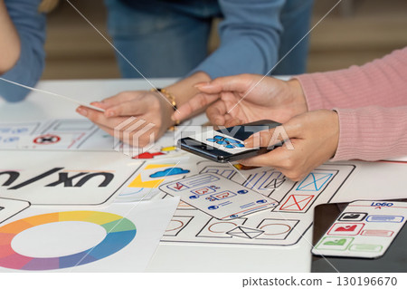 UX and UI Design Team Collaborating with Sketches and Smartphone 130196670