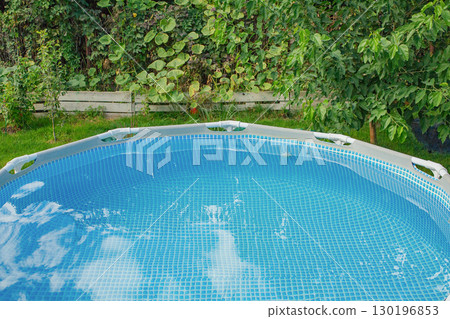 Clear water in the pool against the background of various plants in the garden. Clear water in the pool against the background of various plants in the garden. 130196853