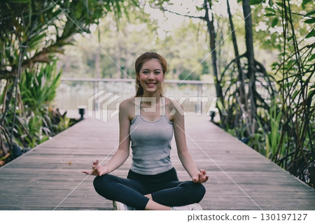 A serene moment of meditation by a young woman in nature, embracing relaxation and mindfulness. A serene moment of meditation by a young woman in nature, embracing relaxation and mindfulness. 130197127