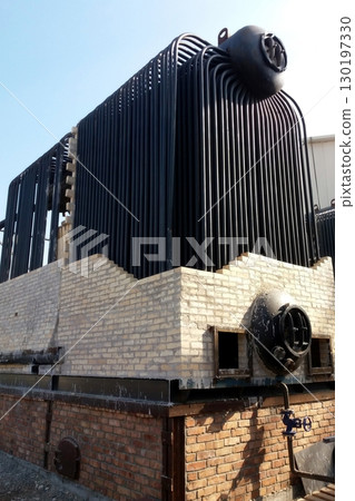 Installation Process of a Large Steam Boiler in an Industrial Setting During Daylight Hours 130197330