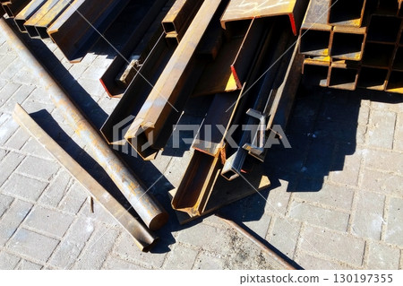 Rolled Metal Lies Stacked in a Construction Area Showing Various Steel Shapes and Sizes 130197355