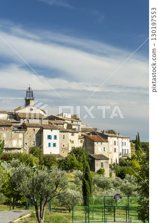 Venterol in Drome, France, showcasing its charming architecture and basketball court under a cloudy sky 130197553