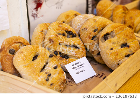 Freshly baked olive fougasse breads displayed in wooden crate at a market in Nyons, France 130197638