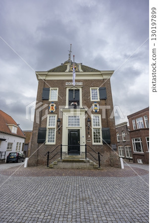 Historic Town Hall of Nieuwpoort in South Holland, Netherlands, standing majestically under cloudy sky 130197899