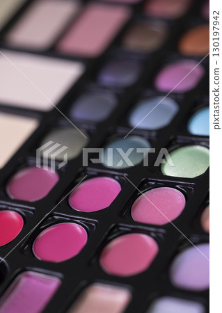 Professional makeup palette showing colorful eyeshadows and lipsticks 130197942