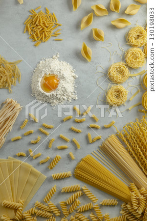 Various types of italian pasta forming a circle around flour and egg yolk 130198033