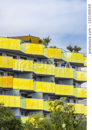 Colorful yellow building with balconies featuring modern architecture in Montpellier, France 130198049