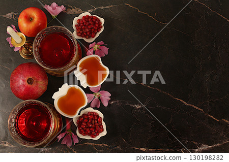 Layout with symbols of the Jewish New Year, template with honey, apples, pomegranate, red wine and flowers. Creative composition for congratulations on the Jewish holiday Ro hashanah, autumn banner Layout with symbols of the Jewish New Year, template with honey, apples, pomegranate, red wine and flowers. Creative composition for congratulations on the Jewish holiday Ro hashanah, autumn banner 130198282