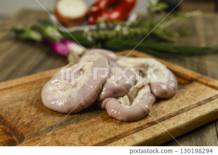 Cow bowels presented on a wooden board with ingredients, ready to grill 130198294
