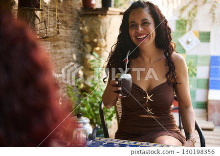 Smiling Woman Enjoying Yerba Mate in a Relaxed Outdoor Setting 130198356