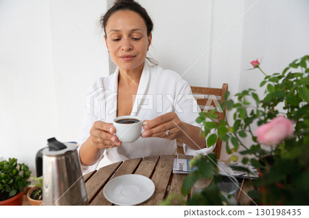 Woman Enjoys Cup of Coffee in Relaxing Outdoor Setting Woman Enjoys Cup of Coffee in Relaxing Outdoor Setting 130198435