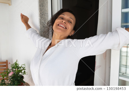 Happy Woman Stretching by an Open Door in Morning Light 130198453